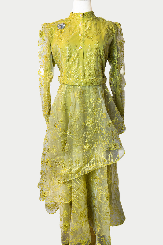 A stunning long layered dress in lemon yellow with sequins and delicate embroidery. The dress has mandarin collar, buttons, long sleeves, and is fully lined. There are hidden zips at the back and sleeves for ease of wear. The design is hijabi-friendly for modesty and style. It also includes a size-adjustable belt for a customized fit.