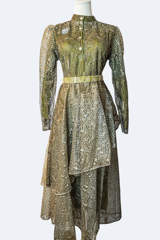 A stunning long layered dress in dark green with delicate embroidery. The dress has mandarin collar, buttons, long sleeves, and is fully lined. There are hidden zips at the back and sleeves for ease of wear. The design is hijabi-friendly for modesty and style. It also includes a size-adjustable belt for a customized fit.